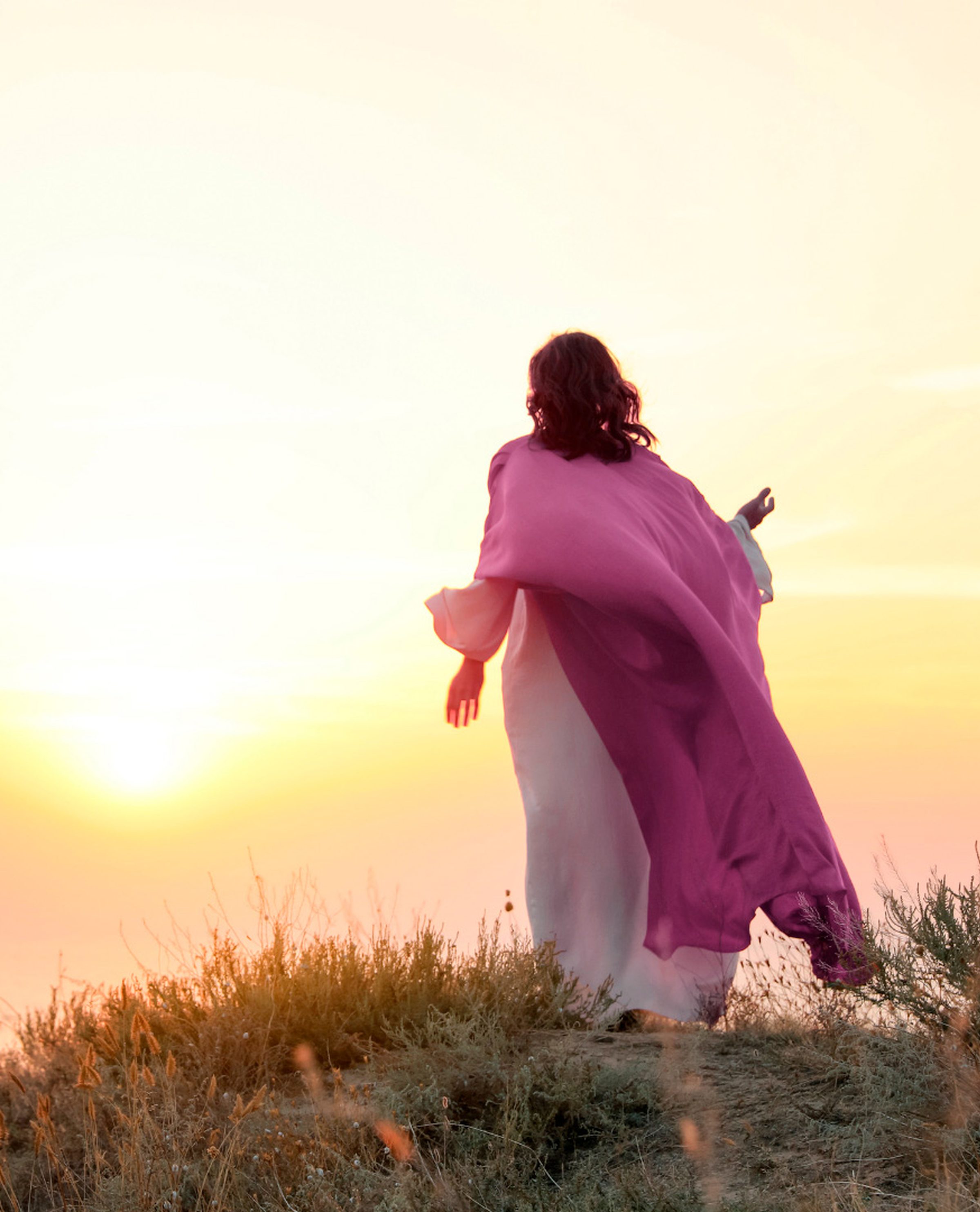Mulher de capa lilás ao pôr do sol