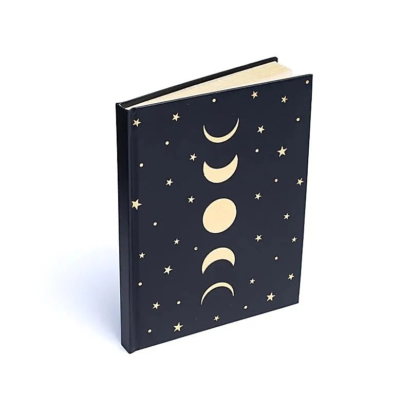 Caderno A5 preto com fases da lua e estrelas na capa para journaling